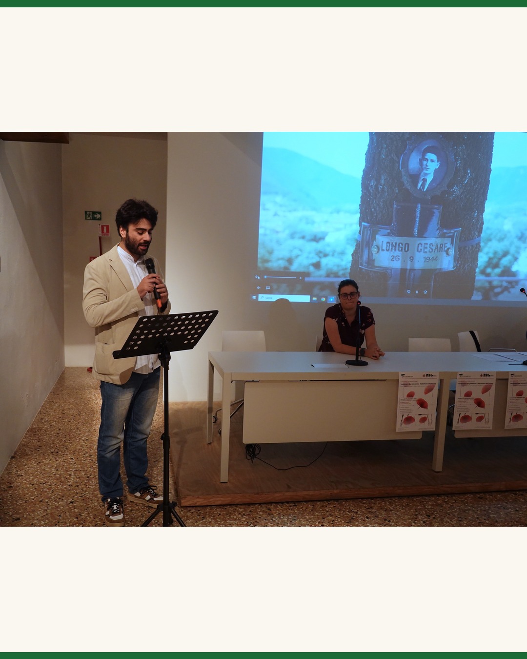Una lettura durante la cerimonia, sullo sfondo la proiezione dedicata a Cesare Longo
